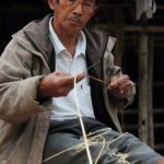A Galo elder weaving baskets